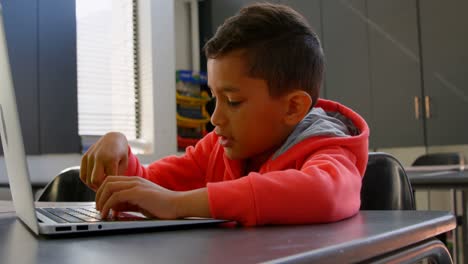 Seitenansicht-Eines-Aufmerksamen-Asiatischen-Schülers,-Der-Mit-Laptop-Im-Klassenzimmer-Der-Schule-4k-Lernt