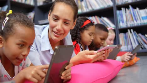 Vista-Frontal-De-Una-Maestra-Caucásica-Y-Niños-De-Escuela-Que-Estudian-En-Una-Tableta-Digital-En-La-Escuela-4k