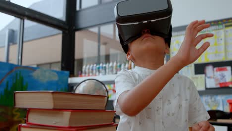 Front-view-of-Asian-schoolboy-using-virtual-reality-headset-in-classroom-at-school-4k