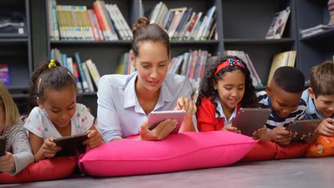 Vista-Frontal-De-Una-Maestra-Caucásica-Y-Niños-De-Escuela-Que-Estudian-En-Una-Tableta-Digital-En-La-Escuela-4k