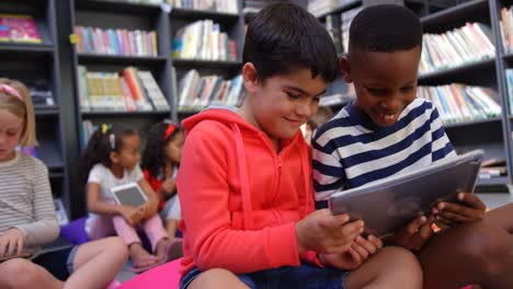 Vorderansicht-Von-Schülern-Gemischter-Abstammung,-Die-In-Der-Schulbibliothek-4k-Auf-Einem-Digitalen-Tablet-Lernen