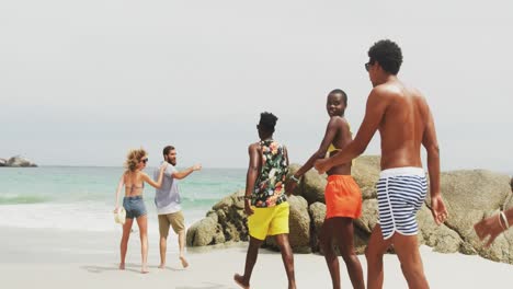 Rear-view-of-mixed-race-friends-walking-on-the-beach-4k