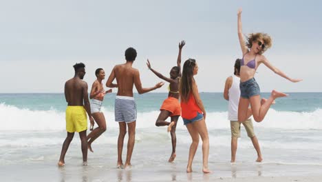 Group-of-mixed-race-friends-dancing-together-on-the-beach-4k
