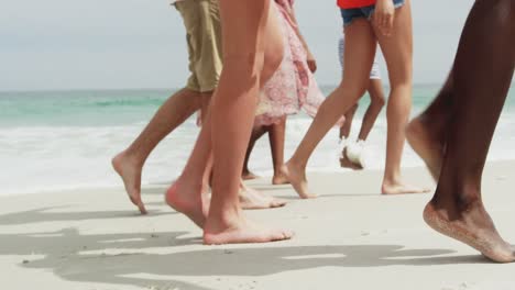 Side-view-of-mixed-race-friends-walking-on-the-beach-4k