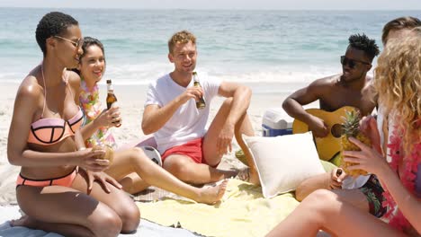 Group-of-mixed-race-friends-interacting-with-each-other-on-the-beach-4k