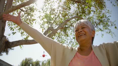 Low-Angle-Ansicht-Einer-Aktiven-Afroamerikanischen-Seniorin,-Die-Im-Garten-Eines-Pflegeheims-Yoga-Macht