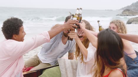 Group-of-mixed-race-friends-toasting-beer-glasses-on-the-beach-4k