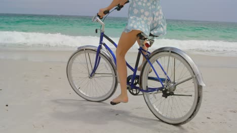 Low-section-of-woman-riding-a-bicycle-on-the-beach-4k