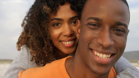 Front-view-of-African-American-couple-embracing-each-other-on-the-beach-4k