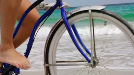 Low-section-of-man-riding-a-bicycle-on-the-beach-4k