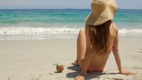 Rear-view-of-Caucasian-woman-in-hat-relaxing-on-the-beach-4k