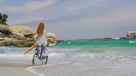 Vista-Trasera-De-Una-Mujer-Caucásica-Andando-En-Bicicleta-En-La-Playa-4k