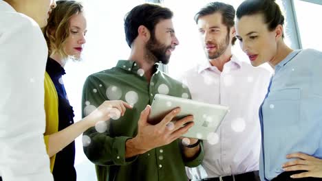 Coworkers-discussing-over-digital-tablet-surrounded-by-white-bubbles-effect