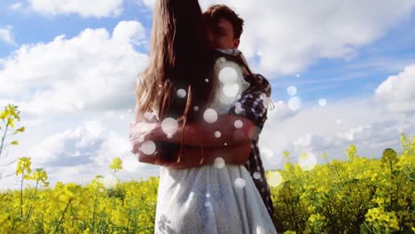 Couple-hugging-on-flower-field-on-sunny-day