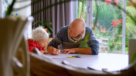 Father-helping-his-daughter-in-drawing-at-home-4k