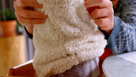 Father-helping-his-daughter-to-put-on-a-sweater-at-home-4k