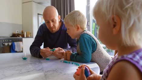 Vater-Und-Kinder-Spielen-Zusammen-Mit-Ton-In-Einem-Komfortablen-Zuhause-4k