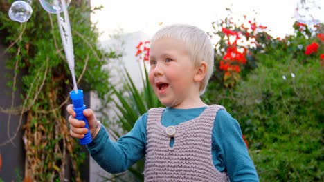 Boy-playing-with-bubble-wand-in-garden-4k