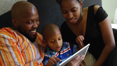Padres-E-Hijo-Usando-Tableta-Digital-En-La-Cama-En-Casa-4k