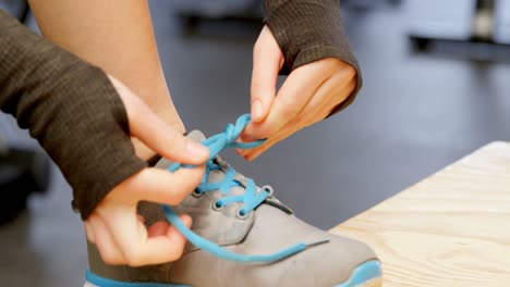 Woman-tying-shoelaces-in-a-fitness-studio-4k