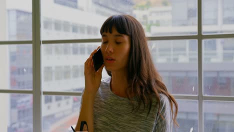 Mujer-De-Negocios-Hablando-Por-Teléfono-Móvil-En-Una-Oficina-Moderna-4k
