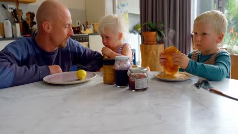 Father-and-children-sitting-at-dining-table-4k