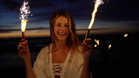 Woman-playing-with-sparklers-on-the-beach-4k