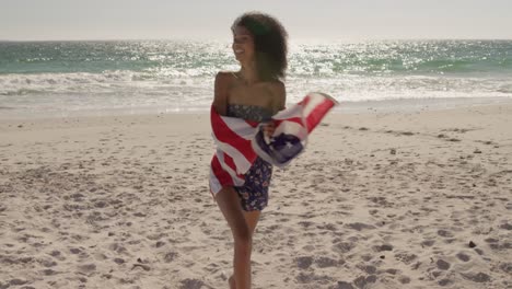 Woman-running-with-American-flag-on-the-beach-4k