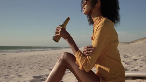 Woman-drinking-beer-on-the-beach-4k
