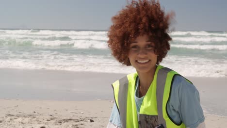 Vista-Frontal-De-Una-Voluntaria-Afroamericana-Limpiando-La-Playa-En-Un-Día-Soleado-4k