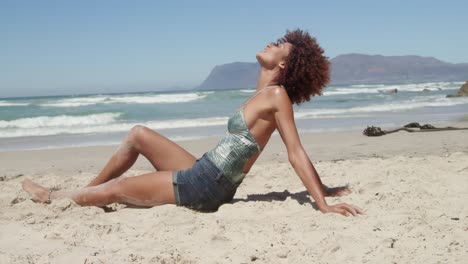 Seitenansicht-Einer-Jungen-Afroamerikanischen-Frau,-Die-Sich-Am-Strand-Entspannt,-4k
