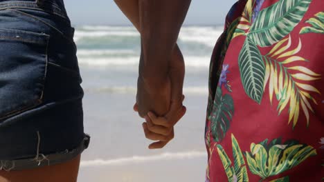 Couple-holding-hands-on-beach-in-the-sunshine-4k