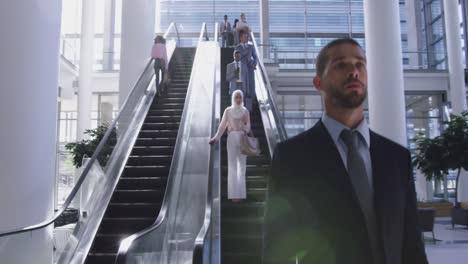 Businessman-moving-downstairs-on-escalator-in-a-modern-office-4k