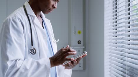 Seitenansicht-Eines-Afroamerikanischen-Männlichen-Arztes-Mit-Digitalem-Tablet-Im-Krankenhaus-4k