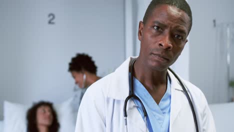 Nahaufnahme-Eines-Afroamerikanischen-Arztes,-Der-In-Die-Kamera-Schaut,-Während-Er-Auf-Der-Station-4k-Auf-Die-Zwischenablage-Schreibt