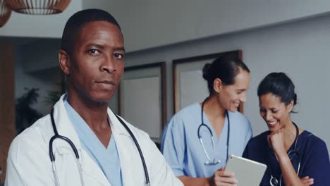Front-view-of-African-american-doctor-with-arm-crossed-looking-at-camera-at-lobby-in-hospital-4k