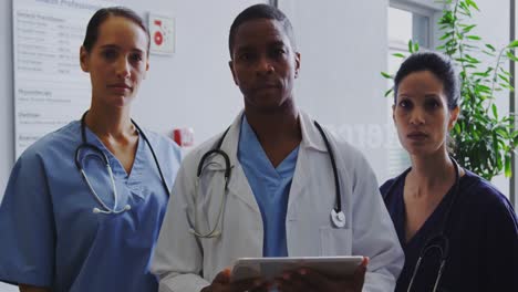 Front-view-of-multi-ethnic-doctors-standing-in-the-corridor-at-hospital-4k