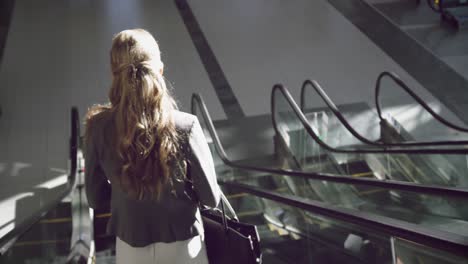 Businesswoman-moving-downstairs-on-escalator-in-the-office-4k