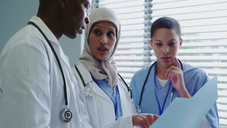 Nahaufnahme-Von-Multiethnischen-Ärzten,-Die-Im-Krankenhaus-über-Einen-Medizinischen-Bericht-Diskutieren