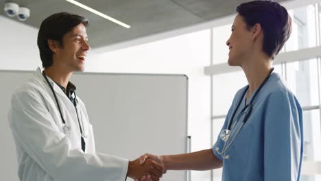 Two-young-doctors-shaking-hands-in-hospital-4k