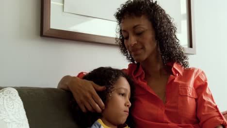 Front-view-of-African-american-mother-consoling-her-son-in-the-lobby-at-hospital-4k