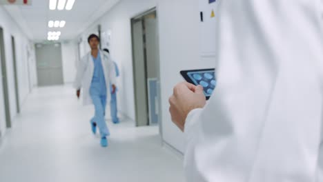 Doctor-walking-in-hospital-corridor-using-tablet-4k