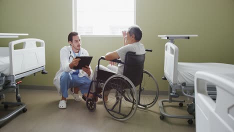 Junger-Arzt-Spricht-Mit-Patient-Im-Rollstuhl-4k