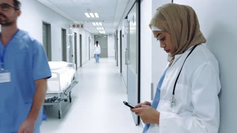 Female-doctor-using-smartphone-in-hospital-corridor-4k