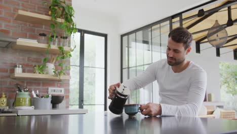 Man-pouring-coffee-in-coffee-cup-at-dining-table-in-a-comfortable-home-4k