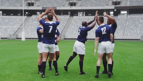 Male-rugby-players-celebrating-goal-in-ground-at-stadium-4k