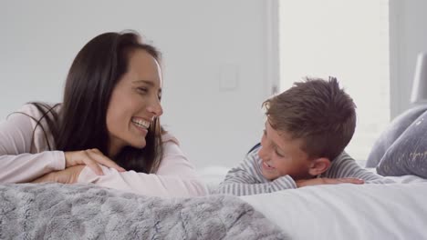 Mother-and-son-lying-together-on-bed-at-home-4k