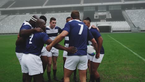 Männliche-Rugbyspieler-Bilden-Gruppen-Im-Boden-4k