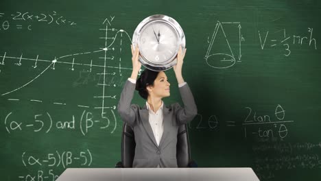 Woman-holding-clock-sitting-in-front-of-chalkboard-with-moving-maths-calculations-on-it-4k