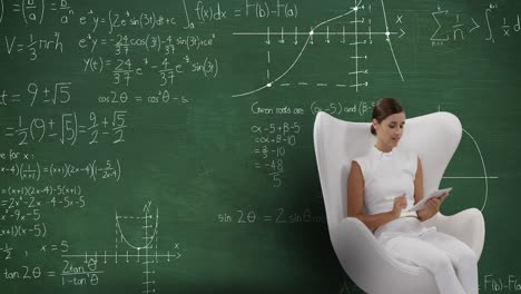 Woman-sitting-using-tablet-in-front-of-chalkboard-with-moving-calculations-on-it-4k